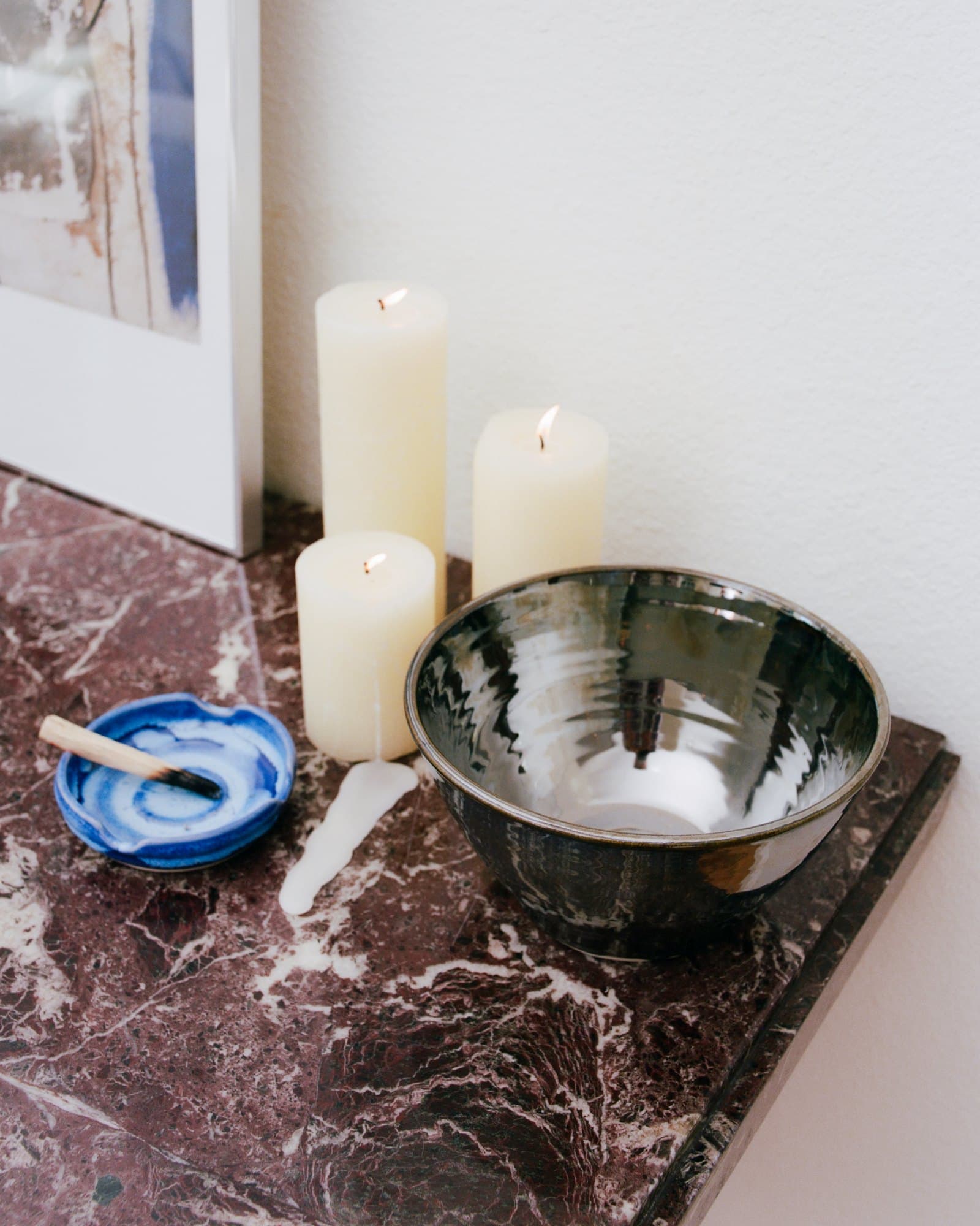 A Studio Nia bowl and dish beside candles on marble