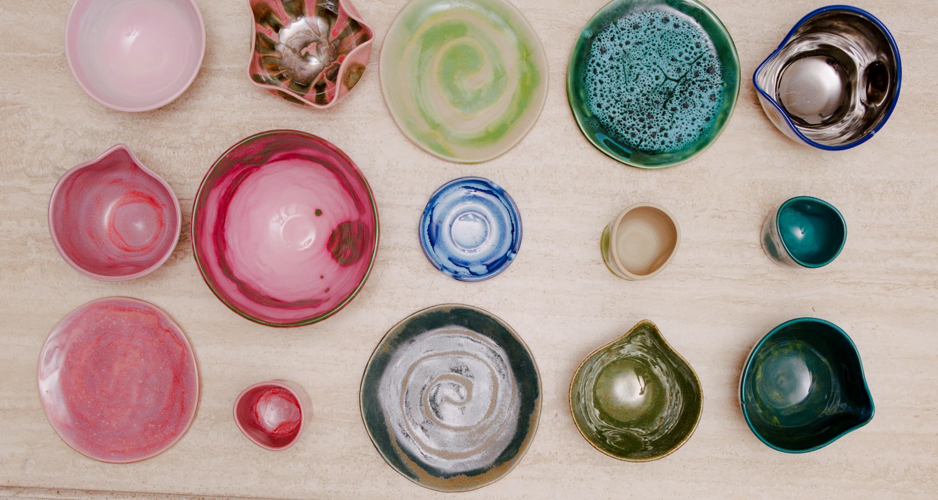 Studio Nia bowls, cups and plates laid out on travertine